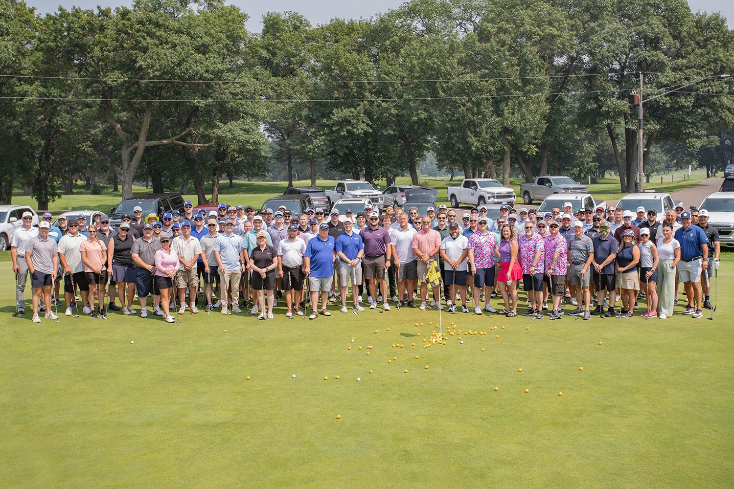 group photo of golf outing participants on the golf course